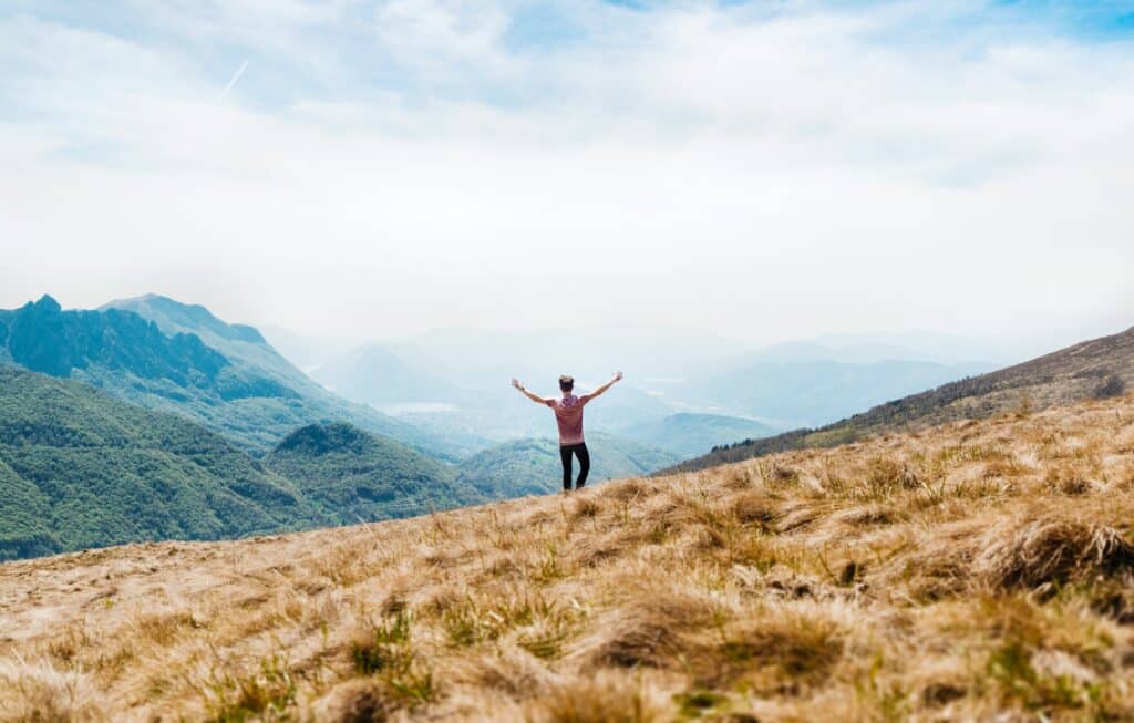 Man standing on mountain with open arms, symbolizing freedom and healing through depression therapy San Francisco.