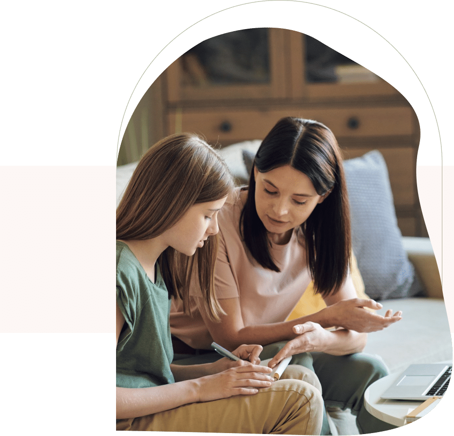 Therapist and teen girl talking and writing notes during session, illustrating CBT for teens in action.