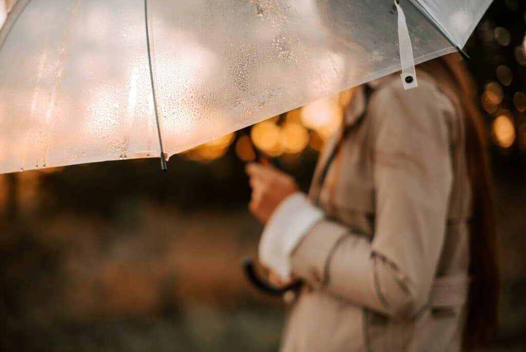 Woman with umbrella at sunset, symbolizing hope through cognitive behavioral therapy for depression in San Francisco.