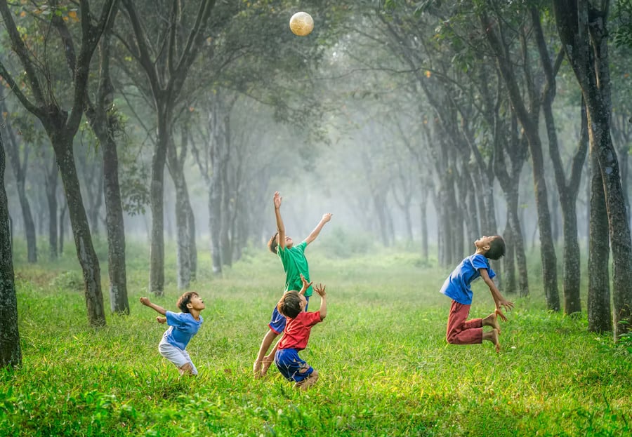 Kids playing with a ball in a field, highlighting growth and support from a teen therapist in San Francisco.