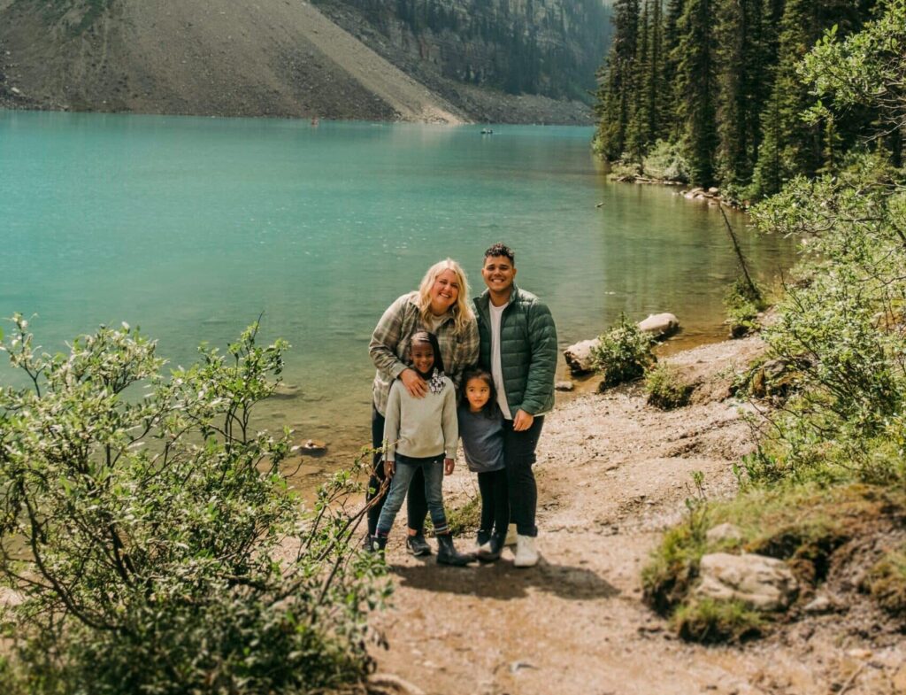 Smiling parents with two children by a lake, showing connection built through parent therapy in San Francisco.